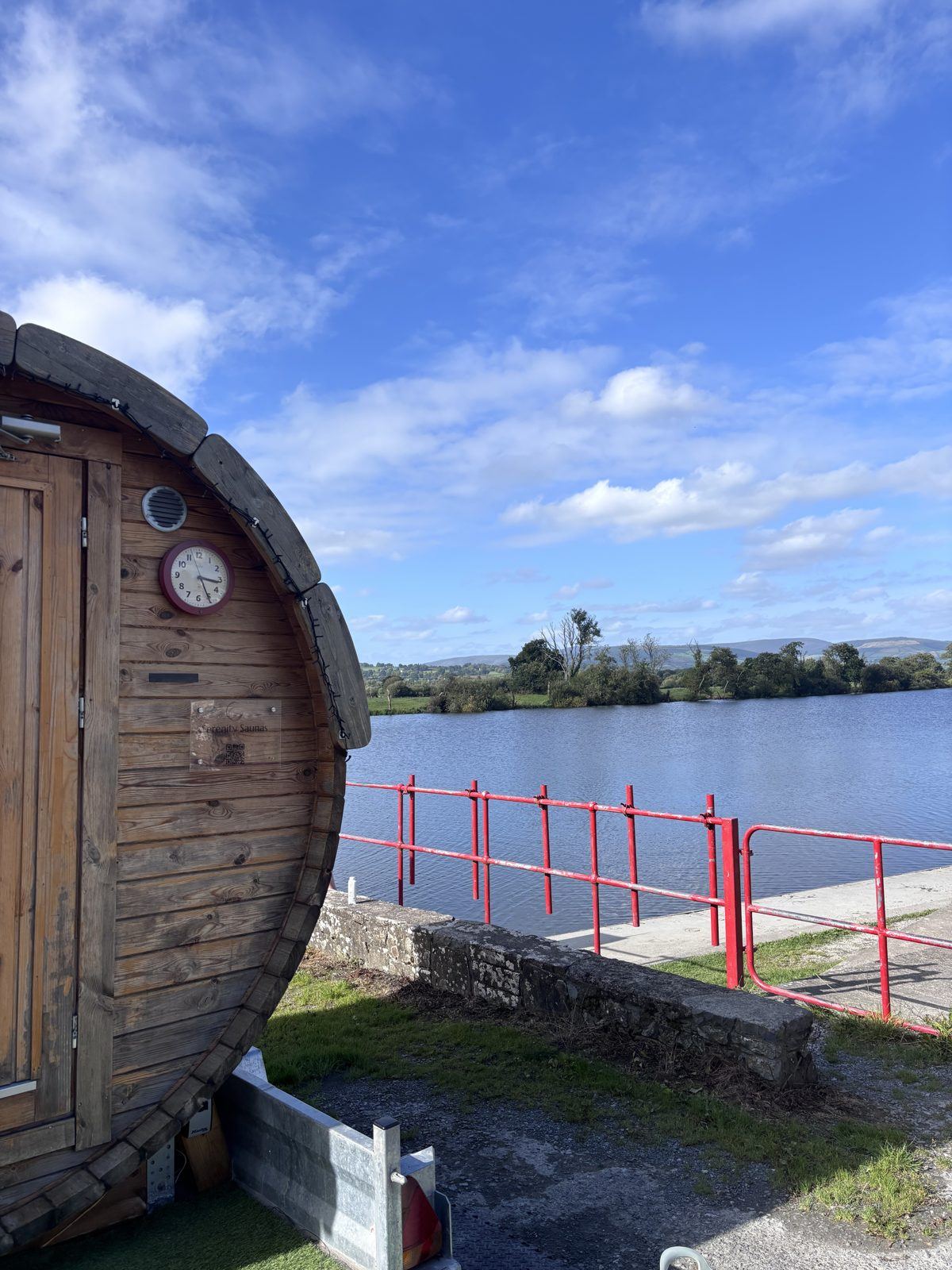 Blue sky over the barrel sauna by the river